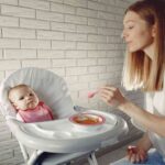 Mom feeding her baby with feeding essentials