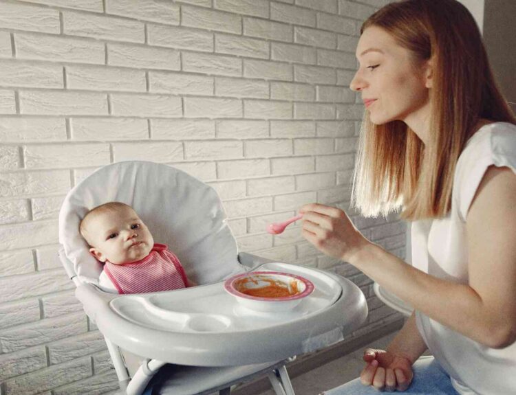 Mom feeding her baby with feeding essentials